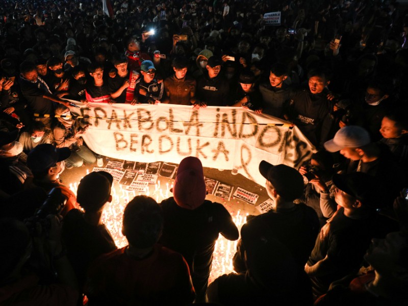 Sejumlah massa aksi pencinta sepak bola menggelar aksi tabur bunga dan 1000 lilin atas tragedi kematian suporter Arema di Stadion Utama Gelora Bung Karno, Jakarta, Minggu (2/10/2022). - Bisnis/Suselo Jati