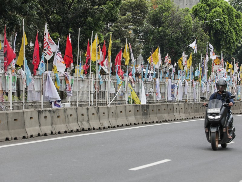 Pengendara melintasi baliho calon anggota legislatif dan partai politik di Jakarta, Senin (8/1/2024)./Bisnis-Fanny Kusumawardhani