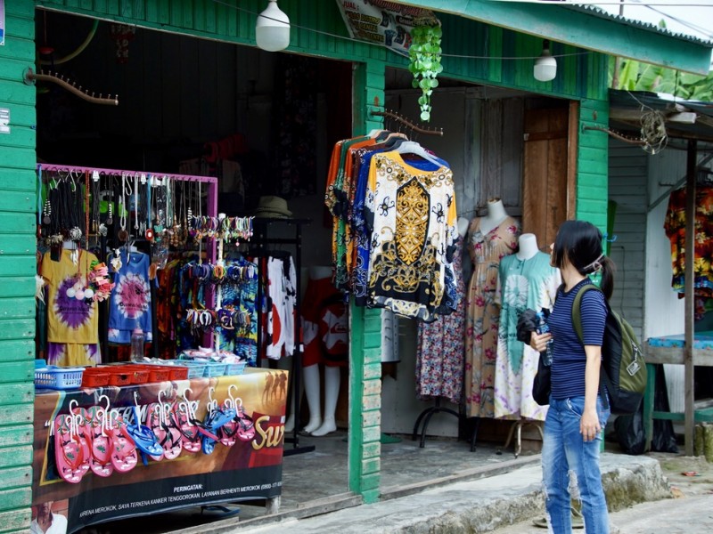 Turis lokal melihat pakaian di salah satu toko di Pulau Derawan