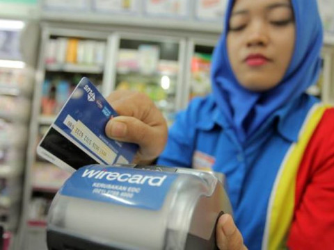 Pegawai menggunakan kartu kredit saat transaksi pembeli.
