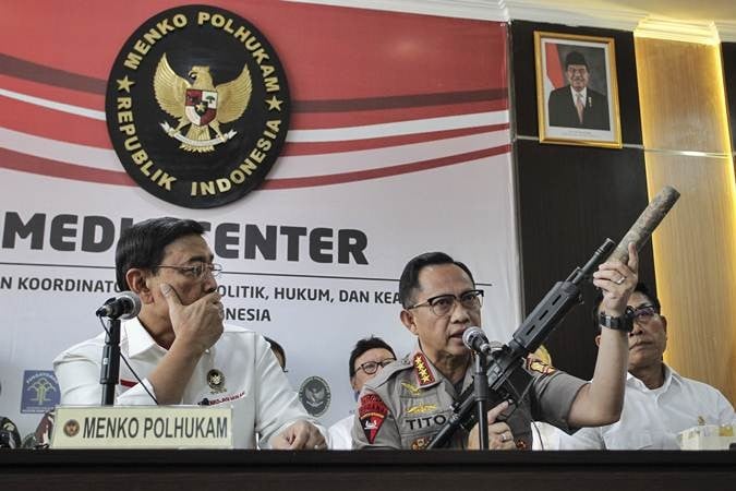 Kapolri Jenderal Pol Tito Karnavian (tengah) disaksikan Menko Polhukam Wiranto (kiri) dan Kepala KSP Moeldoko (kanan) menunjukkan barang bukti senjata api saat menyampaikan konferensi pers perkembangan pascakerusuhan di Jakarta dini hari tadi, di kantor Kemenko Polhukam, Jakarta, Rabu (22/5/2019)./ANTARA-Dhemas Reviyanto