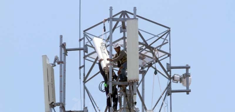 Teknisi memperbaiki BTS di menara telekomunikasi