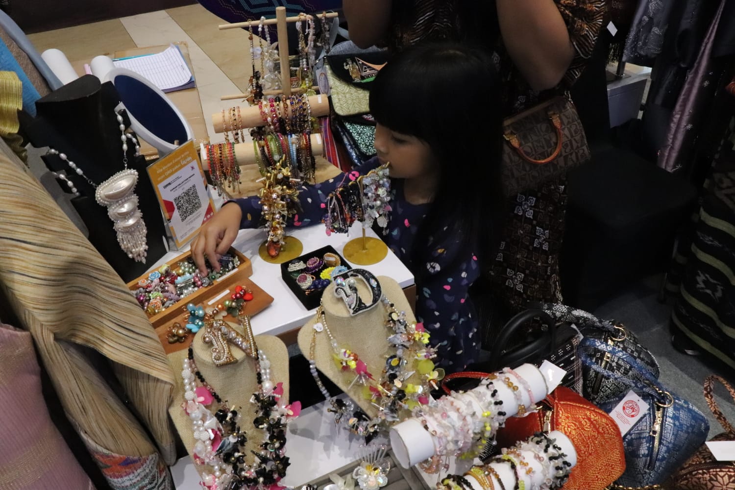 Pengunjung anak-anak ikut memilih aksesoris gelang yang dipamerkan Dekranasda Medan di KKSU 2025.