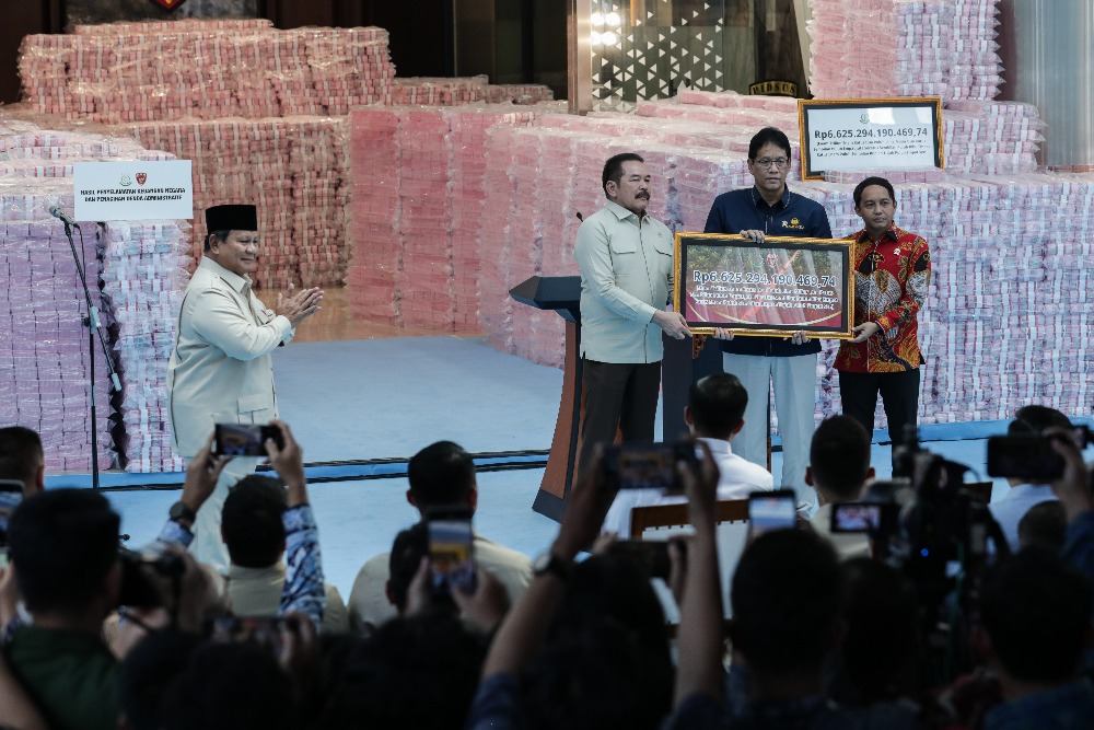 Presiden Prabowo Subianto (kiri) menyaksikan penyerahan uang hasil penyelamatan keuangan negara oleh Jaksa Agung ST Burhanuddin (kedua kiri) didampingi dan Menteri Kehutanan Raja Juli Antoni (kanan) kepada Menteri Keuangan Purbaya Yudhi Sadewa saat konferensi pers Penyerahan Hasil Penyelamatan Keuangan Negara di Kejaksaan Agung, Jakarta, Rabu (24/12/2025). Kejaksaan Agung menyerahkan uang senilai Rp6.625.294.190.469,74 hasil penagihan denda administratif dan penyelamatan keuangan negara kepada pemerintah. JIBI/Bisnis/Fanny Kusumawardhani 