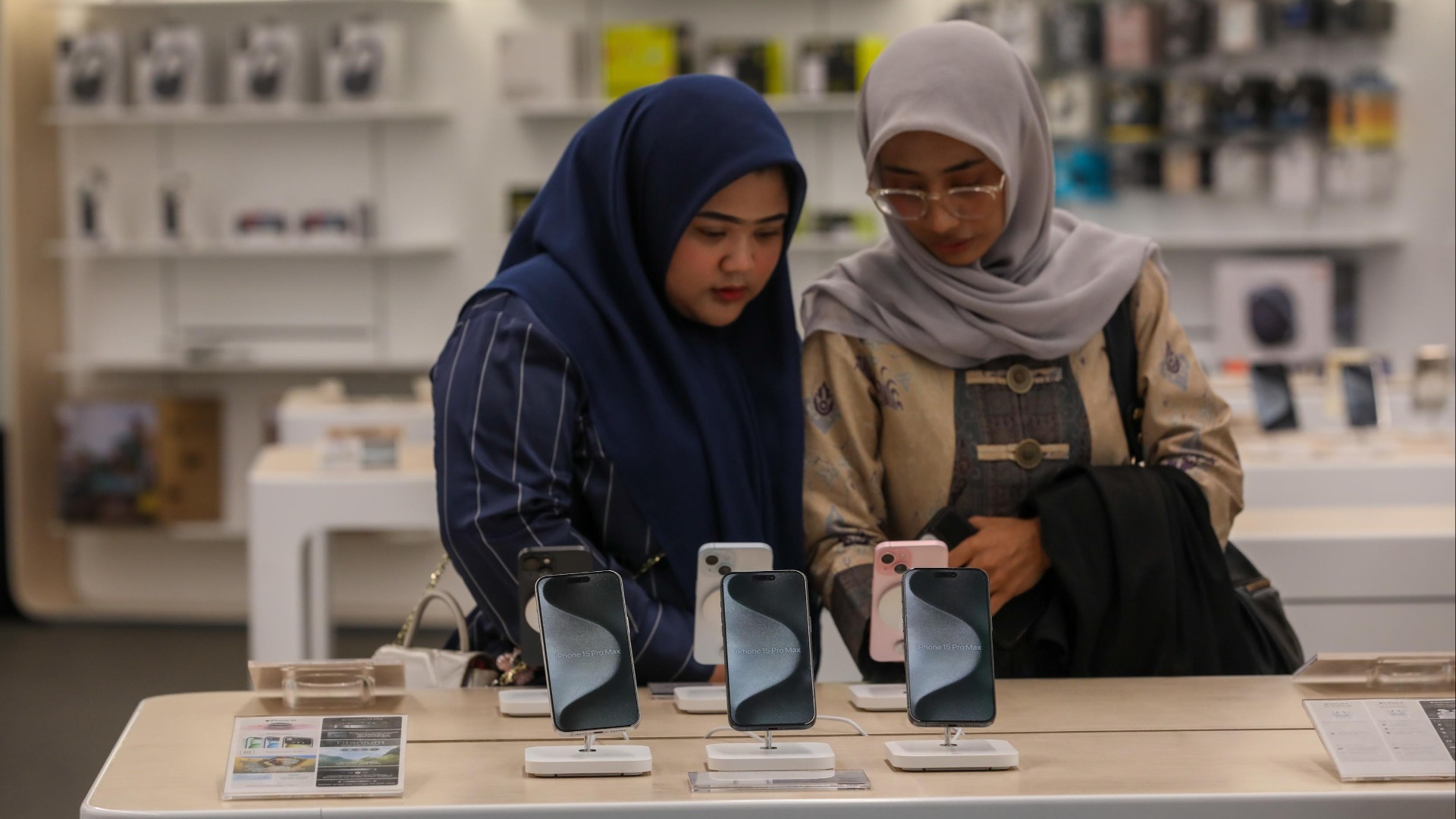 Pengguna mengecek smartphone iPhone dan kesiapan perangkat tersebut adopsi eSIM