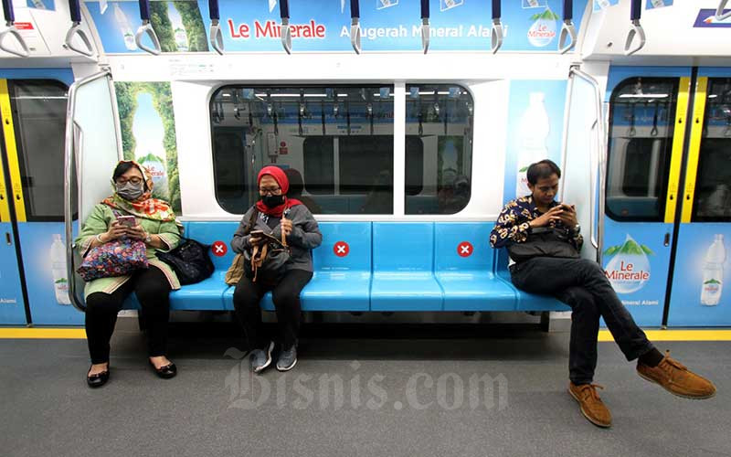 Pekerja menggunakan transportasi umum MRT