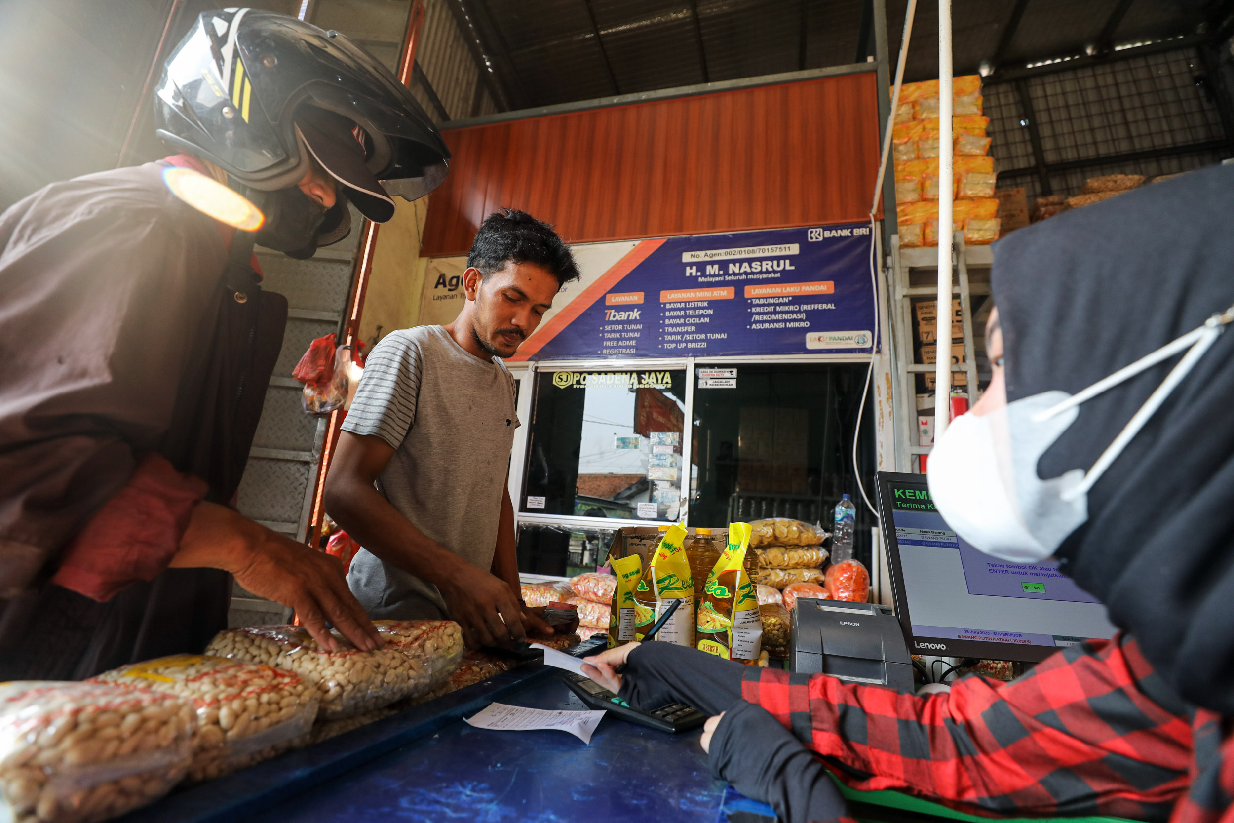 Karyawati melayani pembeli di salah satu agen BRILink di Pasar Parung, Bogor, Jawa Barat, Minggu (19/6). - Bisnis/Arief Hermawan P
