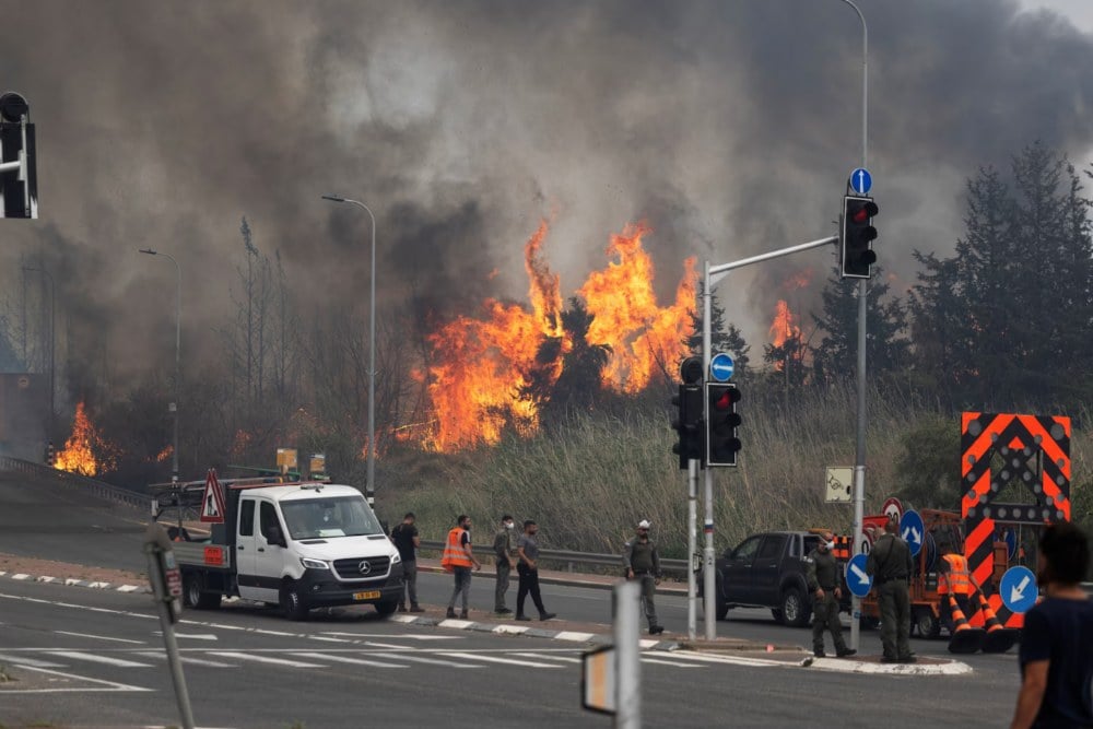 Petugas keamanan dan penyelamat Israel bekerja di dekat Latrun di Israel tengah, saat kebakaran hutan akibat panas ekstrem dan angin melanda Israel tengah, 30 April. REUTERS/Oren Ben Hakoon