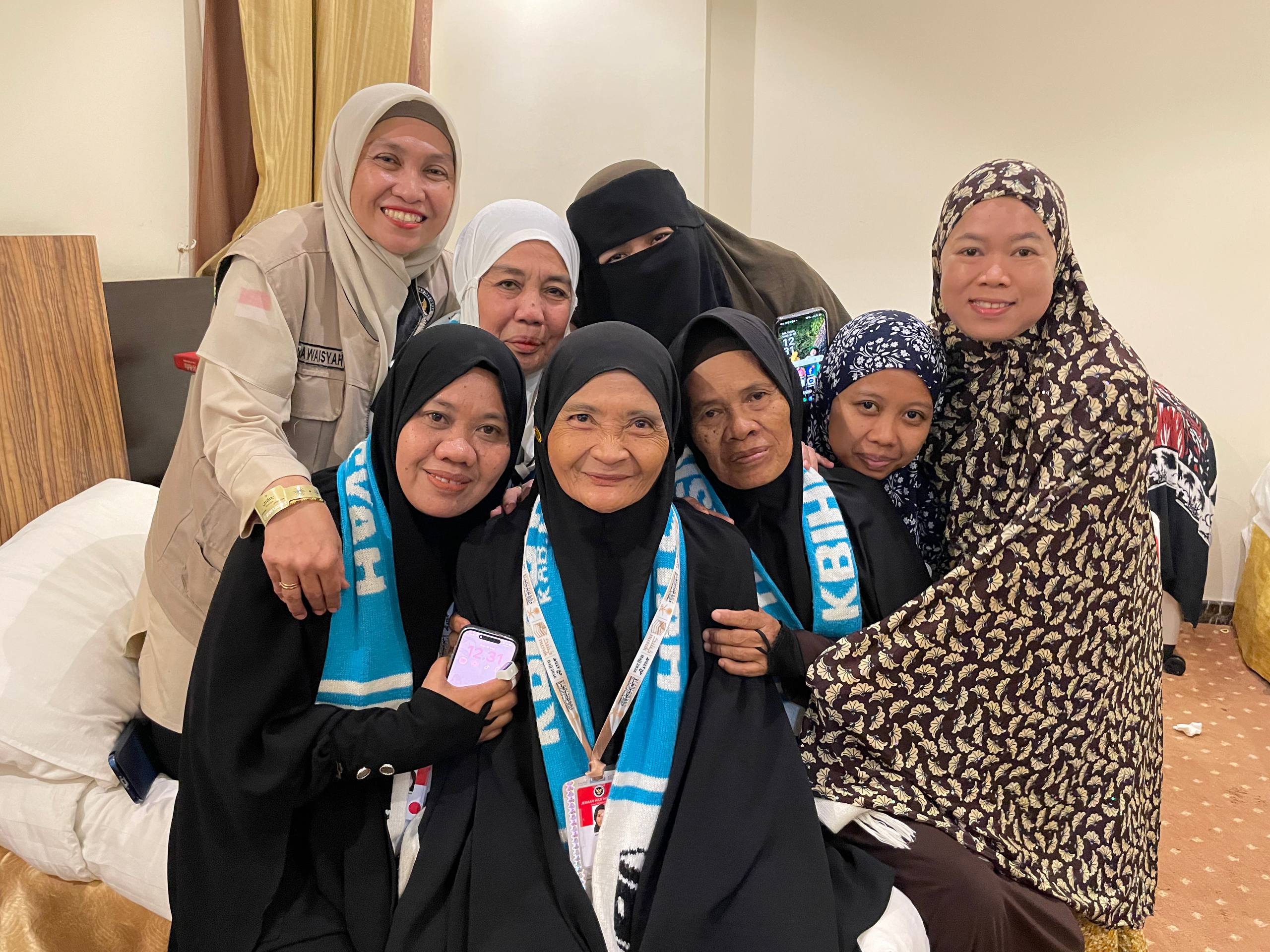 Jumariyah (tengah) bersama para jemaah haji dan petugas haji saat diwawancarai di hotelnya di Makkah, Arab Saudi pada Sabtu (16/5/2026). / Bisnis-Wibi Pangestu Pratama