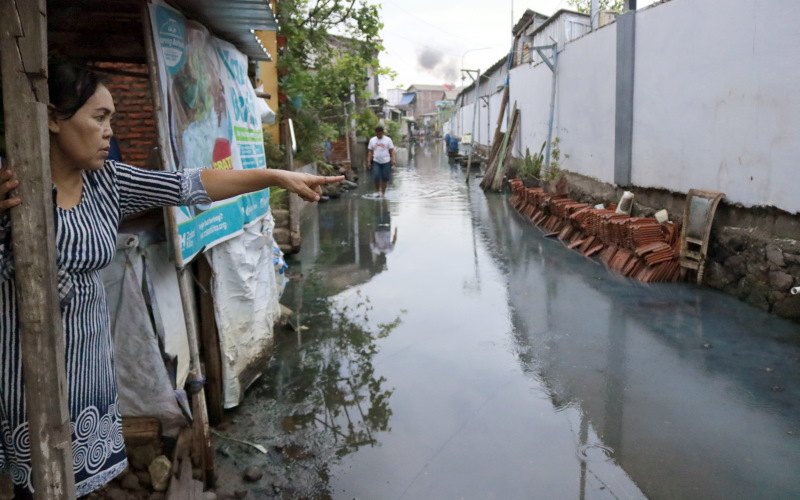 Murtiningsih, warga Tambak Lorok yang rumahnya tergenang banjir rob, menunjukkan ketinggian air. - BISNIS/Muhammad Faisal Nur Ikhsan